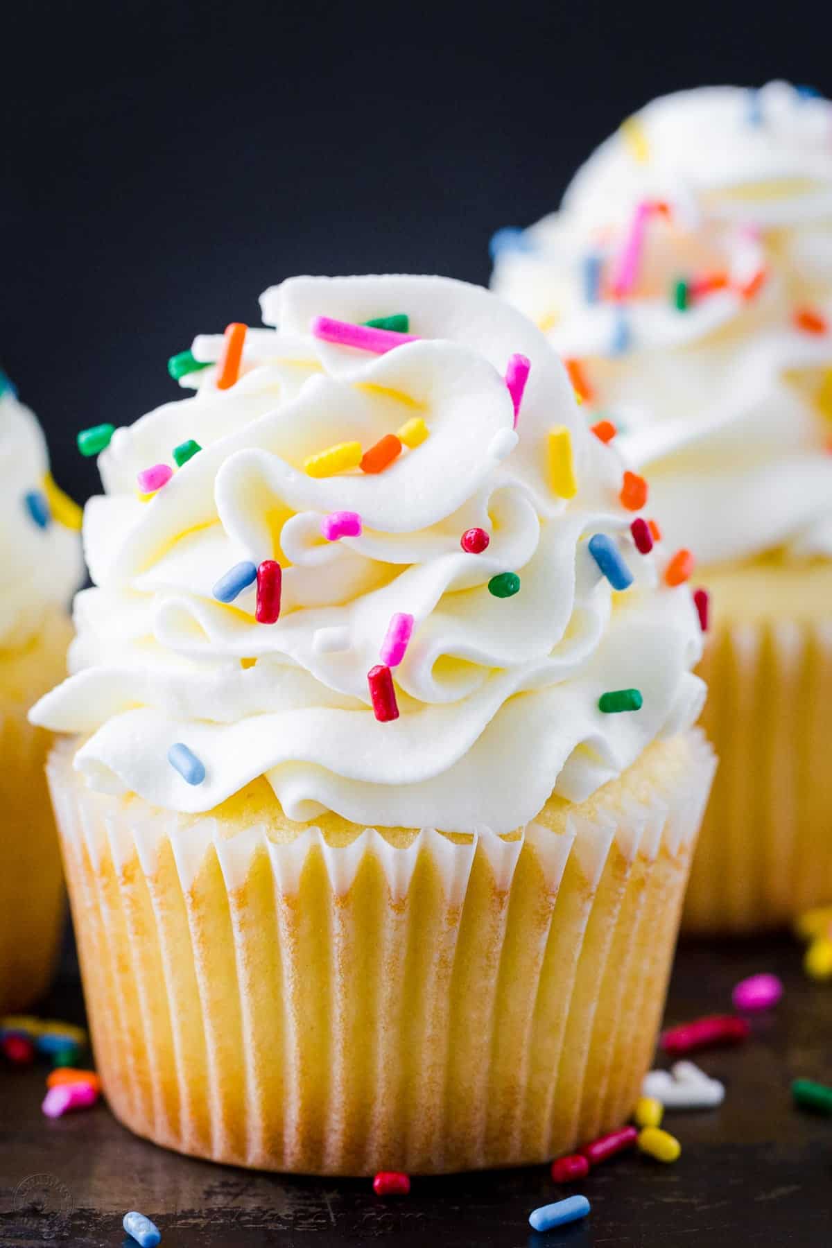 Picture of a vanilla cupcake with sprinkles.